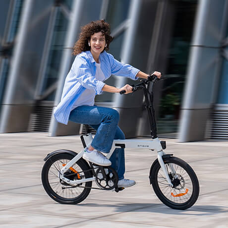 a woman rides a white engwe p20 fold up electric bike