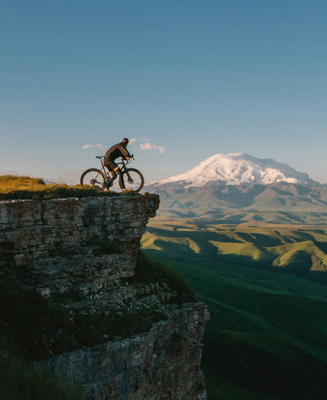 a man leans on an electric bike on a hill